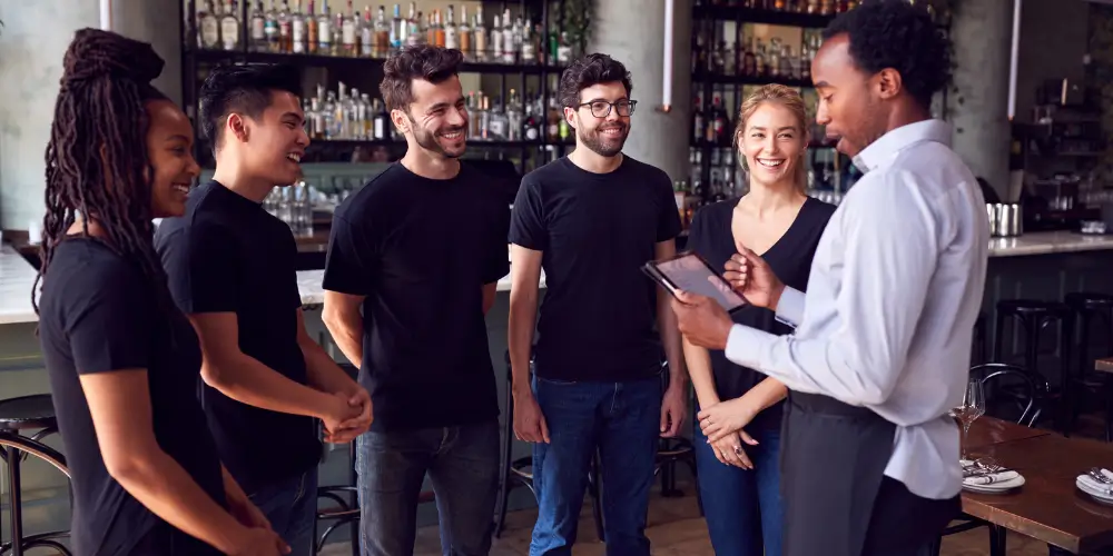 A group of individuals standing together in a bar, engaged in conversation and enjoying their time.