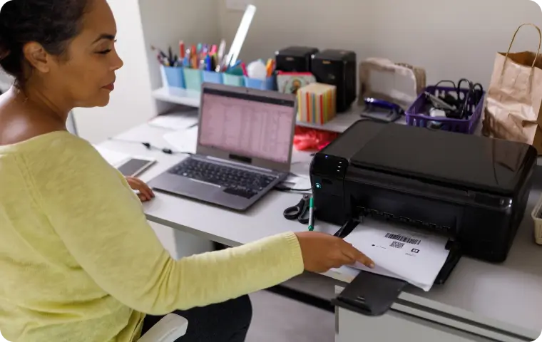 A woman operating a printer to print a document.