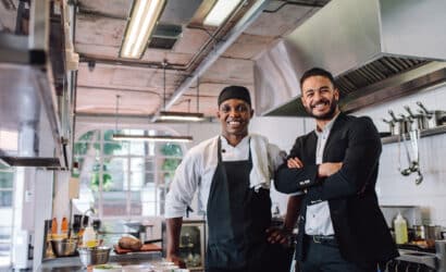 A chef and the restaurant owner standing together in a kitchen