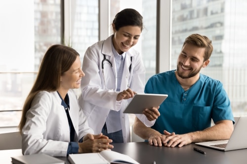 Healthcare professionals examining digital data on a tablet.